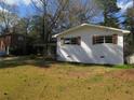 A single-story home with a white brick facade, brown shutters, and a spacious grassy yard at 3531 Creighton Sw Rd, Atlanta, GA 30331
