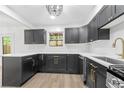 A modern kitchen featuring black cabinetry, stainless steel appliances, and white marble countertops at 6446 E Windsor Ln, Norcross, GA 30093