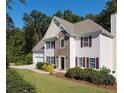 Charming two-story home featuring a stone facade, neutral siding, manicured front yard, and attached two-car garage at 1814 Oak Branch Way, Loganville, GA 30052