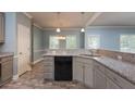 Eat-in kitchen showcasing granite countertops, gray cabinets, black appliances, and tiled floors for a modern look at 1814 Oak Branch Way, Loganville, GA 30052