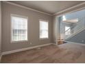 Bright living room featuring neutral-toned walls, plush carpet, white trim, and views of the staircase and adjoining spaces at 1814 Oak Branch Way, Loganville, GA 30052