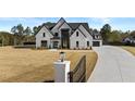 Charming two-story white brick home with black trim and a long driveway at 2485 Brooks Rd, Dacula, GA 30019