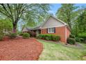 A brick home with manicured landscaping features a walkway leading to the entrance at 1235 Saint Ives Ct, Suwanee, GA 30024
