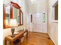 Bright foyer featuring hardwood floors, a decorative mirror, and a white front door with sidelights at 1235 Saint Ives Ct, Suwanee, GA 30024