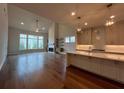 Open-concept living room and kitchen with hardwood floors, fireplace, and lots of natural light at 486 Broom Dr, Cumming, GA 30040