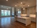 Bright open-concept living room boasts hardwood floors, fireplace, and a wall of windows overlooking the yard at 486 Broom Dr, Cumming, GA 30040