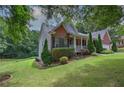 Beautiful home with landscaped lawn on a lush lot with mature trees and an inviting front porch at 51 Muirfield Ct, Hiram, GA 30141