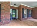 Inviting front porch featuring brick facade, black shutters, and charming curb appeal at 51 Muirfield Ct, Hiram, GA 30141