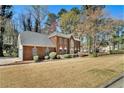 A view of the front yard of a brick home, showcasing its well-maintained lawn and mature landscaping at 5110 Montcalm Sw Dr, Atlanta, GA 30331