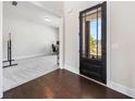 Elegant foyer with a dark wood door, hardwood floors, and view into the home office at 117 Villanueva Rd, Woodstock, GA 30188