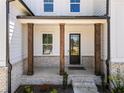 Inviting front porch with brick accents and sturdy wooden support columns at 117 Villanueva Rd, Woodstock, GA 30188