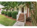 Inviting brick front porch with classic white railings and manicured shrubbery at 4135 Shoshone Valley Rd, Marietta, GA 30068
