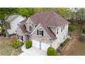 Aerial view of a charming brick home with a well-manicured lawn, two-car garage, and a private backyard at 1074 Frog Leap Nw Trl, Kennesaw, GA 30152