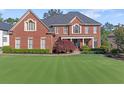 Handsome brick residence featuring an impeccable lawn, tasteful landscaping, and a covered entry offering classic charm at 5124 Parkwood Oaks Ln, Smyrna, GA 30126
