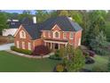 A brick two-story home with mature trees and lush bushes surrounding the property at 5124 Parkwood Oaks Ln, Smyrna, GA 30126