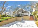 Exterior view of a home with beige siding and a welcoming front porch with white railings and retaining wall at 2362 Virginia Ne Pl, Atlanta, GA 30305
