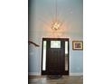 Elegant entryway featuring a stylish light fixture, attractive front door, and tasteful decor at 3440 Camelot Way, Loganville, GA 30052