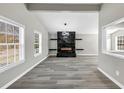 Spacious living room with a decorative fireplace and modern gray floors, with a glimpse to the kitchen at 3690 Darrah Sw Way, Atlanta, GA 30331