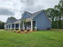 Beautiful blue home with a well-maintained lawn and manicured landscaping on a spacious lot at 476 Benson Meadows Dr, Dallas, GA 30157