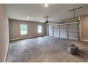 Spacious garage with a large overhead door, concrete floor, and windows for natural light at 476 Benson Meadows Dr, Dallas, GA 30157