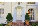 Charming front entrance with brick walkway, arched doorway, and manicured potted plants at 41 Palisades Ne Rd, Atlanta, GA 30309