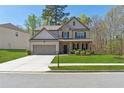 Well-maintained two-story home with lush green lawn, a convenient two-car garage, and sidewalk at 2096 Hamilton Lake Pkwy, Buford, GA 30519