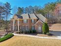 View of a stately brick home with a manicured lawn and mature landscaping at 5615 Toccoa Dr, Douglasville, GA 30135