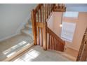 Carpeted staircase featuring wood railing and a light-filled landing at 606 Se Riverview Dr # 606, Marietta, GA 30067