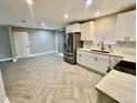 Open-concept kitchen and living area with stainless steel appliances, white cabinets and ample counter space at 6123 Deerfield Ct, Morrow, GA 30260
