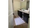 Bathroom featuring modern vanity with dark cabinetry, white rug, and tile floors at 6802 Potomac, Fairburn, GA 30213