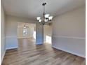 Open-concept dining area featuring modern light fixture, wood floors, and wainscoting at 6808 Foxfire Pl, South Fulton, GA 30349