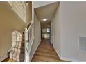 Bright hallway with hardwood floors, leading to a kitchen with white cabinets at 6808 Foxfire Pl, South Fulton, GA 30349
