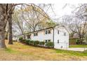 View of the side of the charming, white-brick home with freshly manicured landscaping in a lovely yard at 3888 W Oak Dr, Douglasville, GA 30135