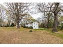 Spacious side yard of this home in a wooded setting with mature trees, offering ample outdoor space at 3888 W Oak Dr, Douglasville, GA 30135
