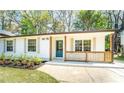 Charming one-story home with a well-manicured lawn, fresh flowers, and a blue front door at 716 Sunfield Nw Dr, Lilburn, GA 30047