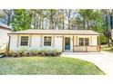 Charming one-story home with a well-manicured lawn, fresh flowers, and natural wood porch accents at 716 Sunfield Nw Dr, Lilburn, GA 30047