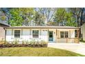 Charming one-story home with a well-manicured lawn, fresh flowers, and natural wood porch accents at 716 Sunfield Nw Dr, Lilburn, GA 30047