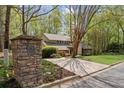 View of the home from the street featuring a stone mailbox, driveway, and a lush, green front yard at 420 Longs Peak, Johns Creek, GA 30022