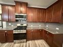 Modern kitchen features granite countertops, stainless steel appliances, and wood cabinets at 2460 Laurel Gate Ln, Cumming, GA 30040