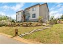 Modern residence with a stone retaining wall, lush lawn, and a stylish stepped pathway to the entrance at 4232 Edgewood Ct, Marietta, GA 30068