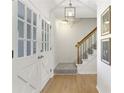 Bright entryway with hardwood floors, staircase, white french doors, and stylish light fixture at 520 Willeo Rd, Roswell, GA 30075