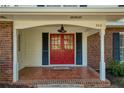 Inviting front porch featuring a red double door, brick pillars, and 'sweet home' welcome mat at 520 Willeo Rd, Roswell, GA 30075
