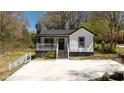 Charming home featuring a covered porch and freshly poured driveway at 665 S Eugenia Nw Pl, Atlanta, GA 30318