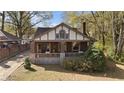 Quaint two-story home with brick and stone accents, complemented by mature trees and greenery at 1716 Rogers Sw Ave, Atlanta, GA 30310