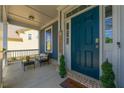 Inviting front porch featuring a cozy seating area and a stylish blue front door, enhancing curb appeal at 3218 Garden Hill Ln, Douglasville, GA 30135