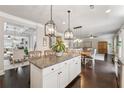 Open-concept kitchen with granite countertops, a central island, pendant lighting, and hardwood floors at 406 Dunaway Ct, Grayson, GA 30017