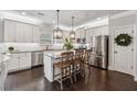 Bright kitchen featuring stainless steel appliances, white cabinets, a central island, and hardwood floors at 406 Dunaway Ct, Grayson, GA 30017