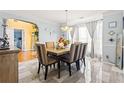Elegant dining room with stylish chairs, modern chandelier, and bright window at 859 Pownal Ln, Hampton, GA 30228