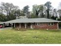 Brick home with a covered carport, adorned with decorative columns and a neatly landscaped front yard at 2678 Oswood Dr, Tucker, GA 30084