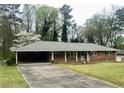 Single story brick home with a covered carport, cozy front porch, and a well-manicured lawn at 2678 Oswood Dr, Tucker, GA 30084